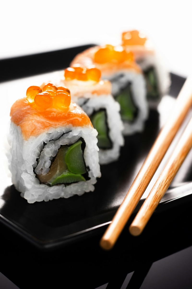 Chopsticks picking up a piece of fresh sashimi